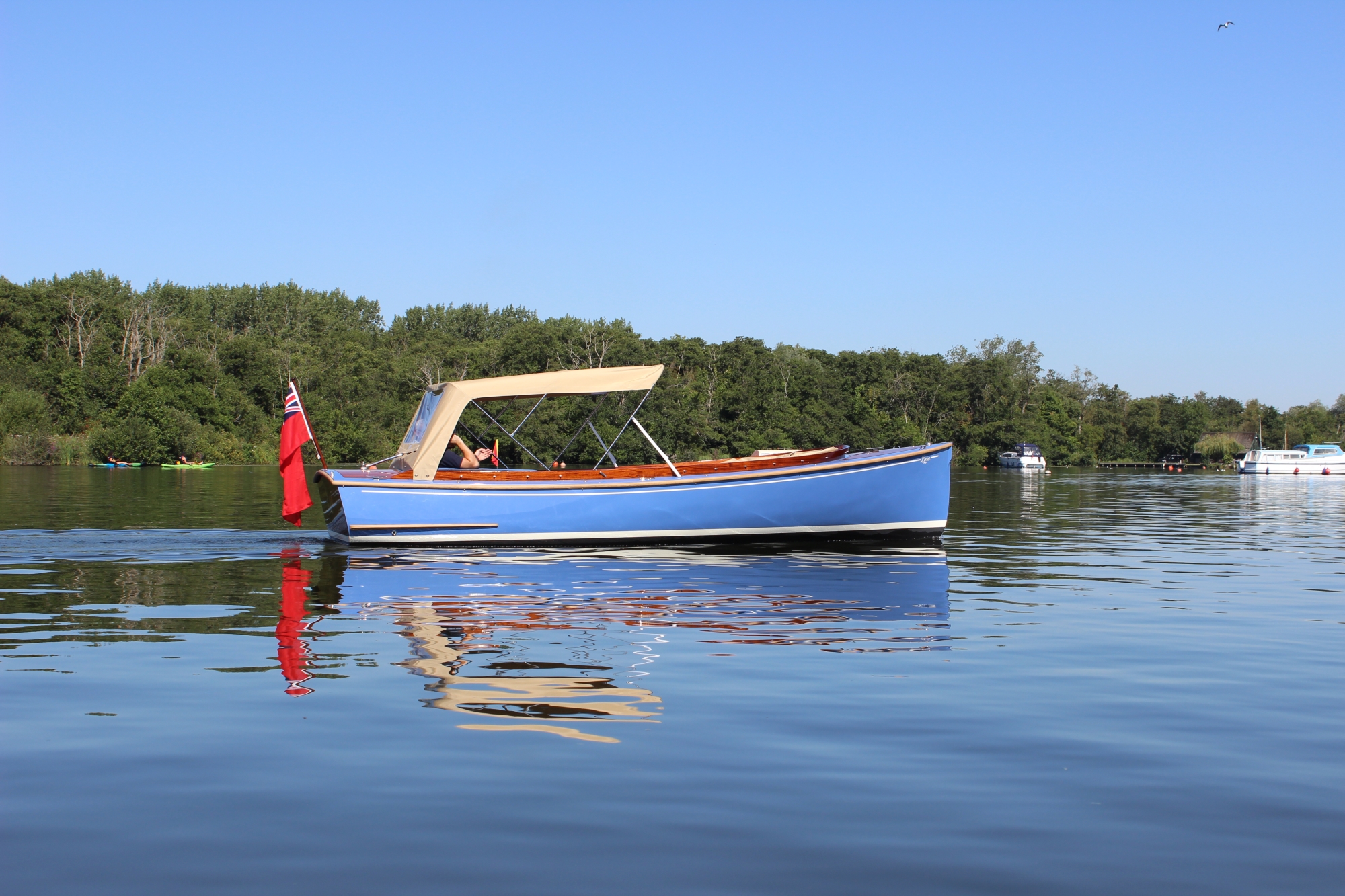 Blue boat driving across lake